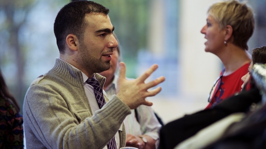 Mohammad Al Sallakh next to poster