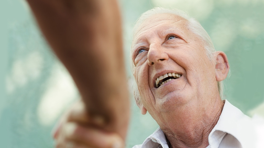 Older man smiling and shaking hands