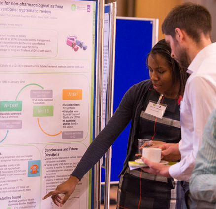 Researchers discussing a poster